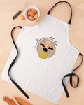 White apron with a design and text on a wooden surface with kitchen items.