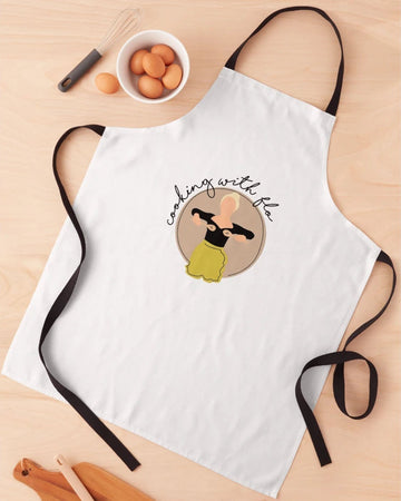 White apron with a design and text on a wooden surface with kitchen items.