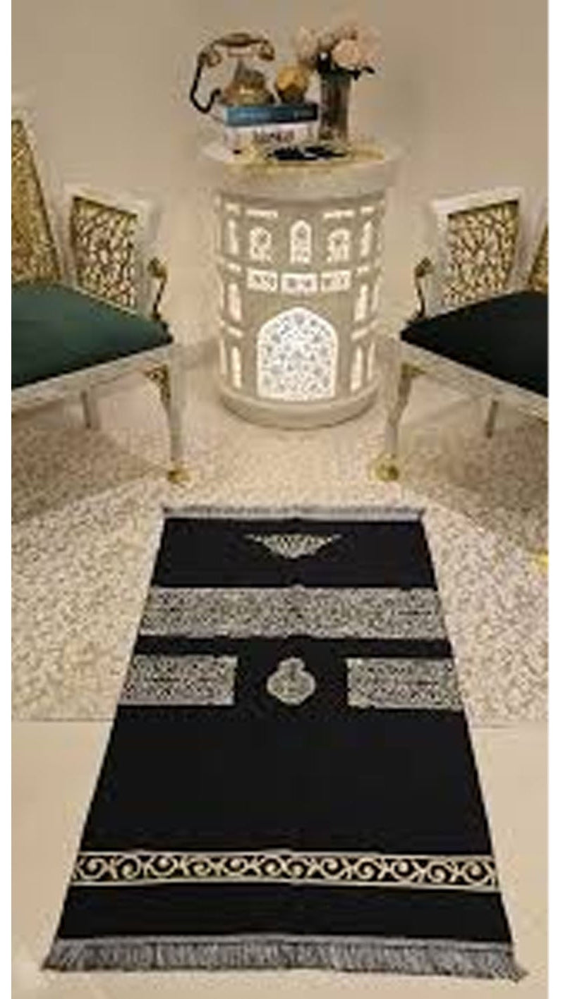 Decorative black and white patterned rug on a marble floor with chairs and a table in the background.