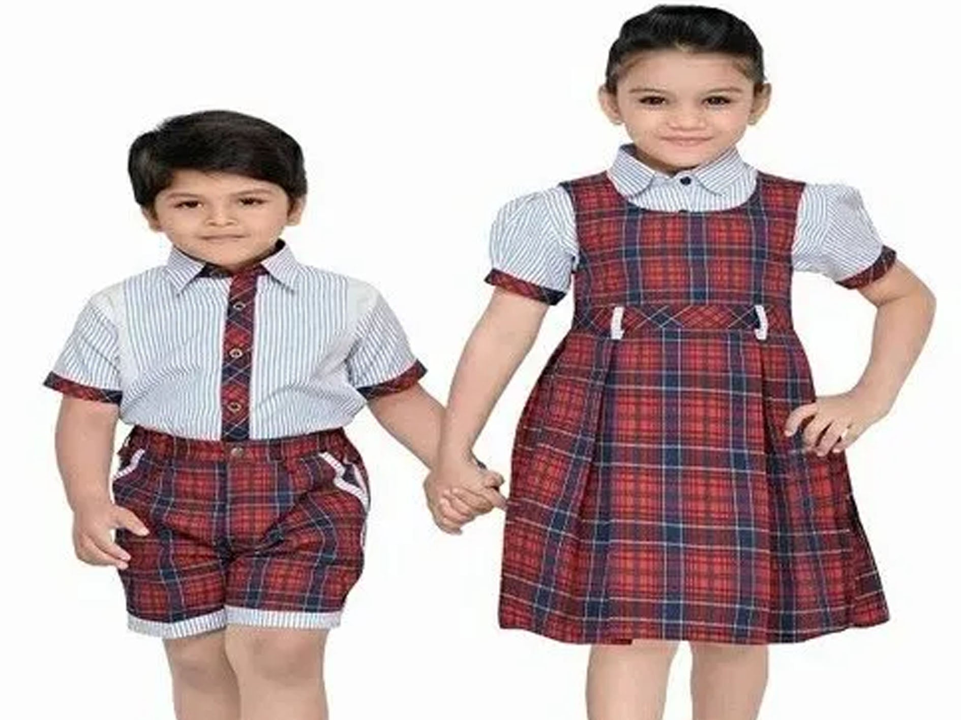 Two children wearing matching school uniforms with a boy in a shirt and shorts and a girl in a dress.
