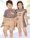 Two children wearing matching outfits with a white background