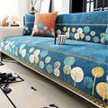 Blue floral-patterned sofa cover on a white sofa with decorative pillows.