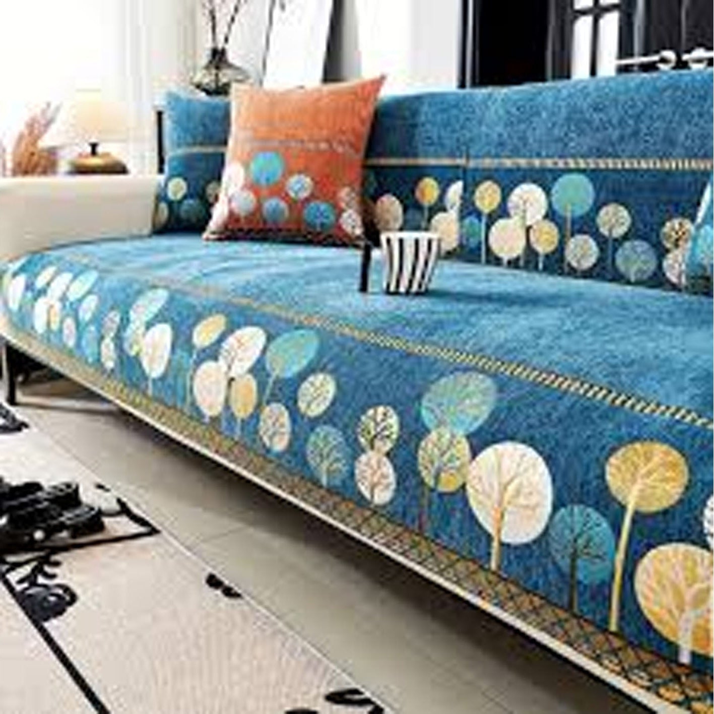 Blue floral-patterned sofa cover on a white sofa with decorative pillows.