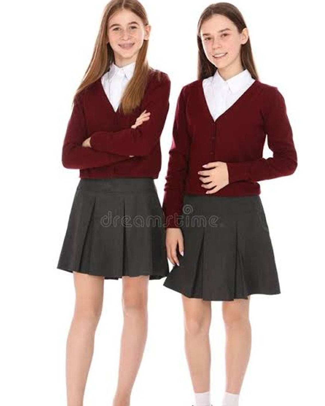 Two young girls modeling matching school uniform sets consisting of a maroon cardigan over a white collared shirt and a dark gray pleated skirt, against a plain white background.