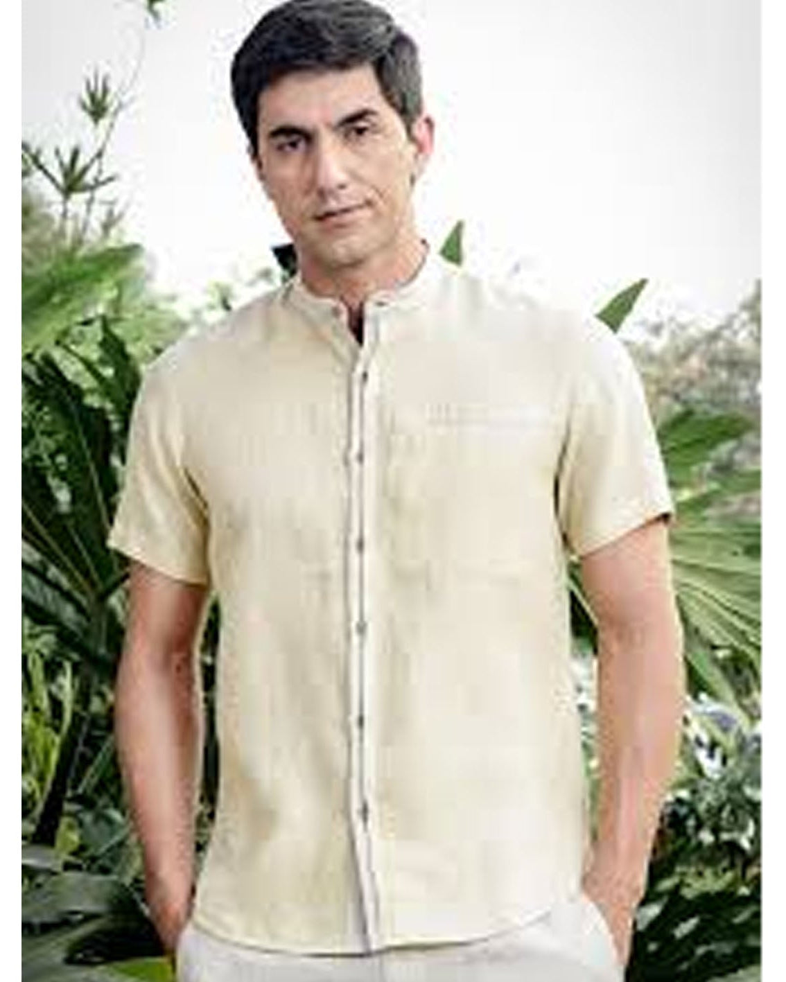 Man wearing a beige shirt with a blurred natural background