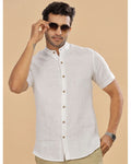 Man wearing a white short-sleeve shirt with a beige background