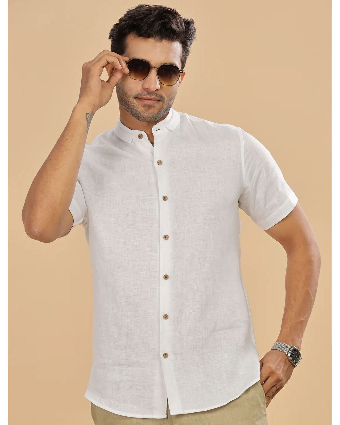Man wearing a white short-sleeve shirt with a beige background