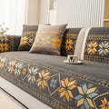Decorative floral-patterned sofa cover on a gray sofa with cushions.