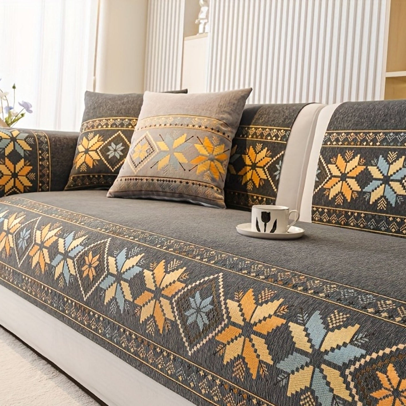 Decorative floral-patterned sofa cover on a gray sofa with cushions.