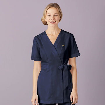 Woman wearing a navy blue uniform against a light purple background