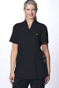 Woman wearing a black scrub top with a logo on a white background
