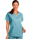 A woman modeling a light blue V-neck scrub top and matching scrub pants against a plain white background.