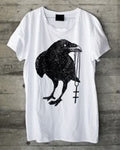 White t-shirt with a black crow design on a wooden surface