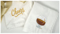 Two white napkins with embroidered designs on a light gray background