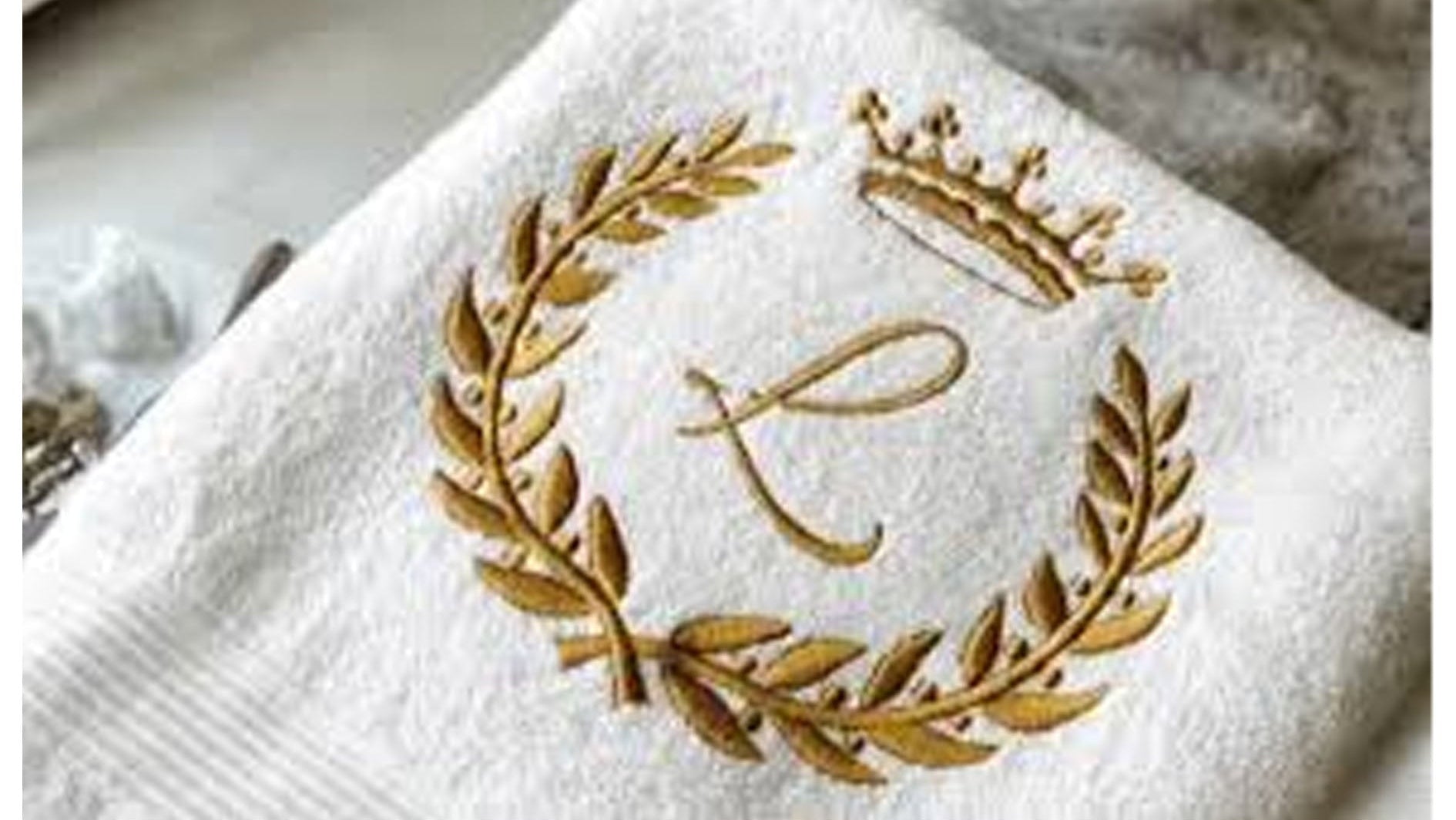 White Towel with L embroidered on a grey background