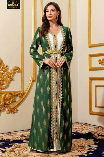 Woman in a green and gold dress standing in an ornate room with gold decorations.