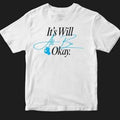 A white short-sleeve crewneck t-shirt with a printed graphic on the chest reading 'It's Will All Be Okay.' in black and light blue script, accompanied by a small blue paw print, shown against a solid black background.