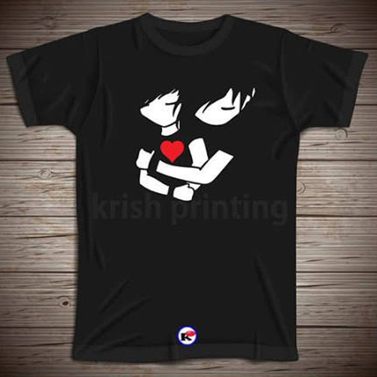 A black short-sleeve t-shirt with a graphic print of two white anime-style hands holding a red heart, displayed flat on a brown wood plank background.