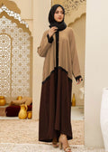 Woman wearing a beige and brown outfit with a hijab in an ornate interior setting.