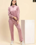 Woman wearing a pink tracksuit against a beige background