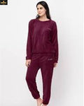 Woman wearing a burgundy lounge set on a white background
