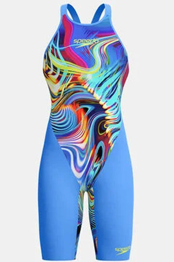 A Speedo women's one-piece swimsuit featuring a bright blue base with a vibrant, multicolored psychedelic swirl pattern on the torso, set against a plain light gray background.