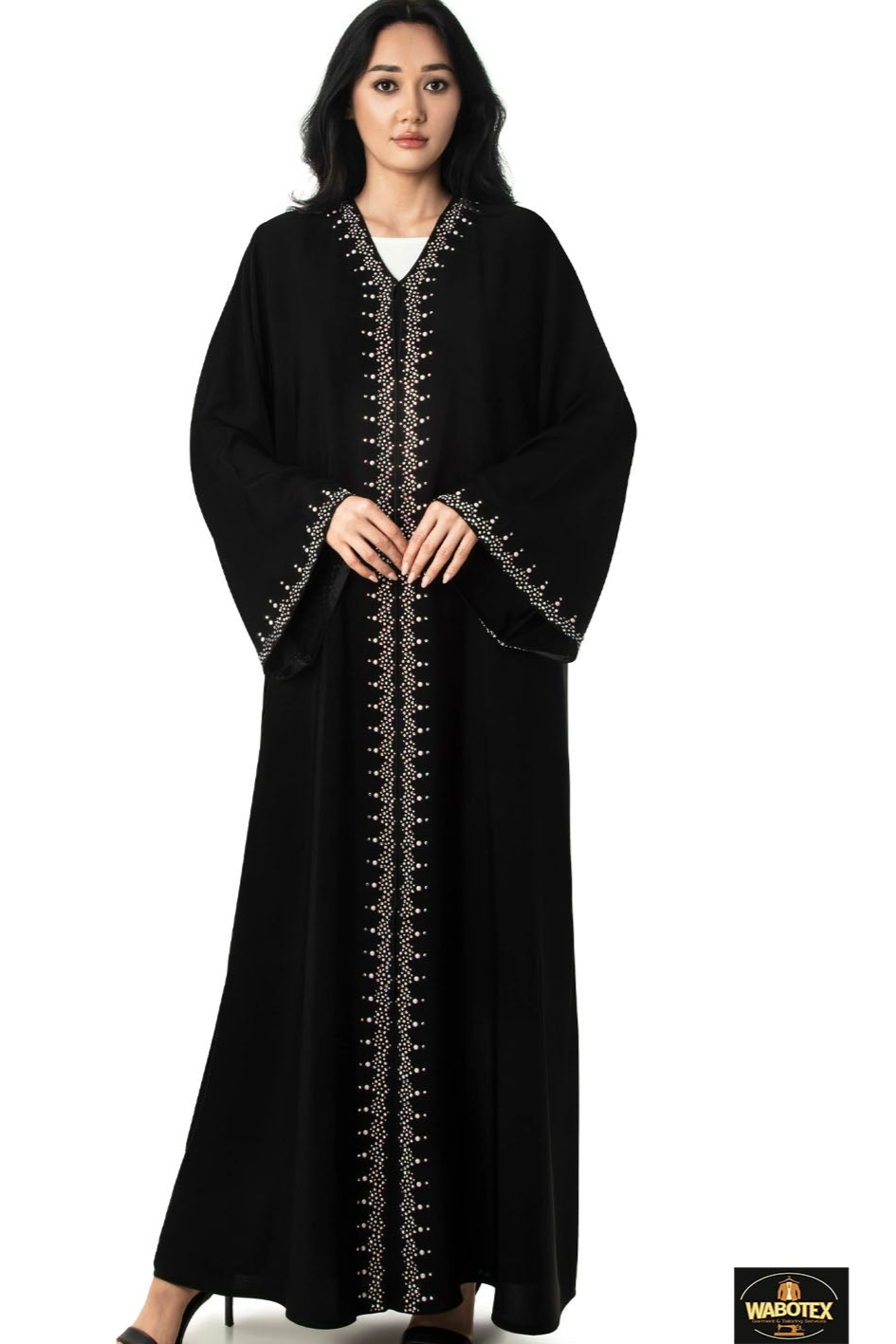Woman wearing a black abaya with gold embroidery on a white background