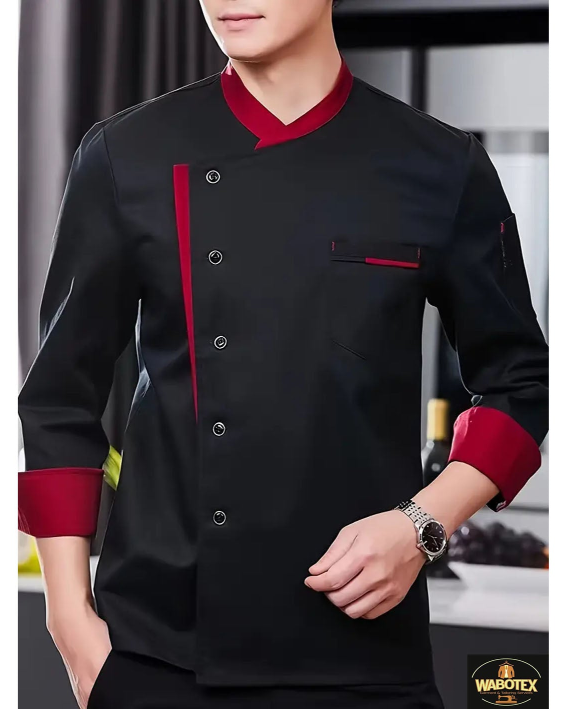 Person wearing a black chef's jacket with red accents in a kitchen setting