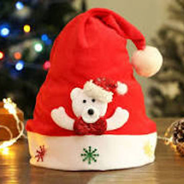 Red Santa hat with a white bear design on a wooden surface with Christmas decorations in the background.
