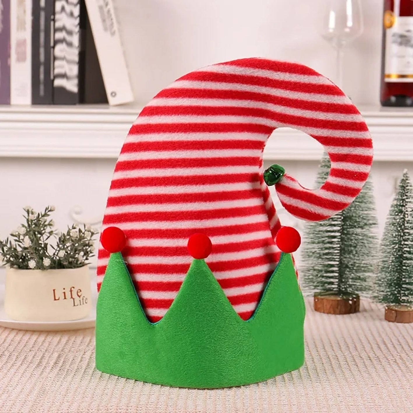 Red and green striped candy cane-shaped decoration on a white surface with a blurred background.
