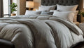 Gray comforter on a bed with pillows in a bedroom setting