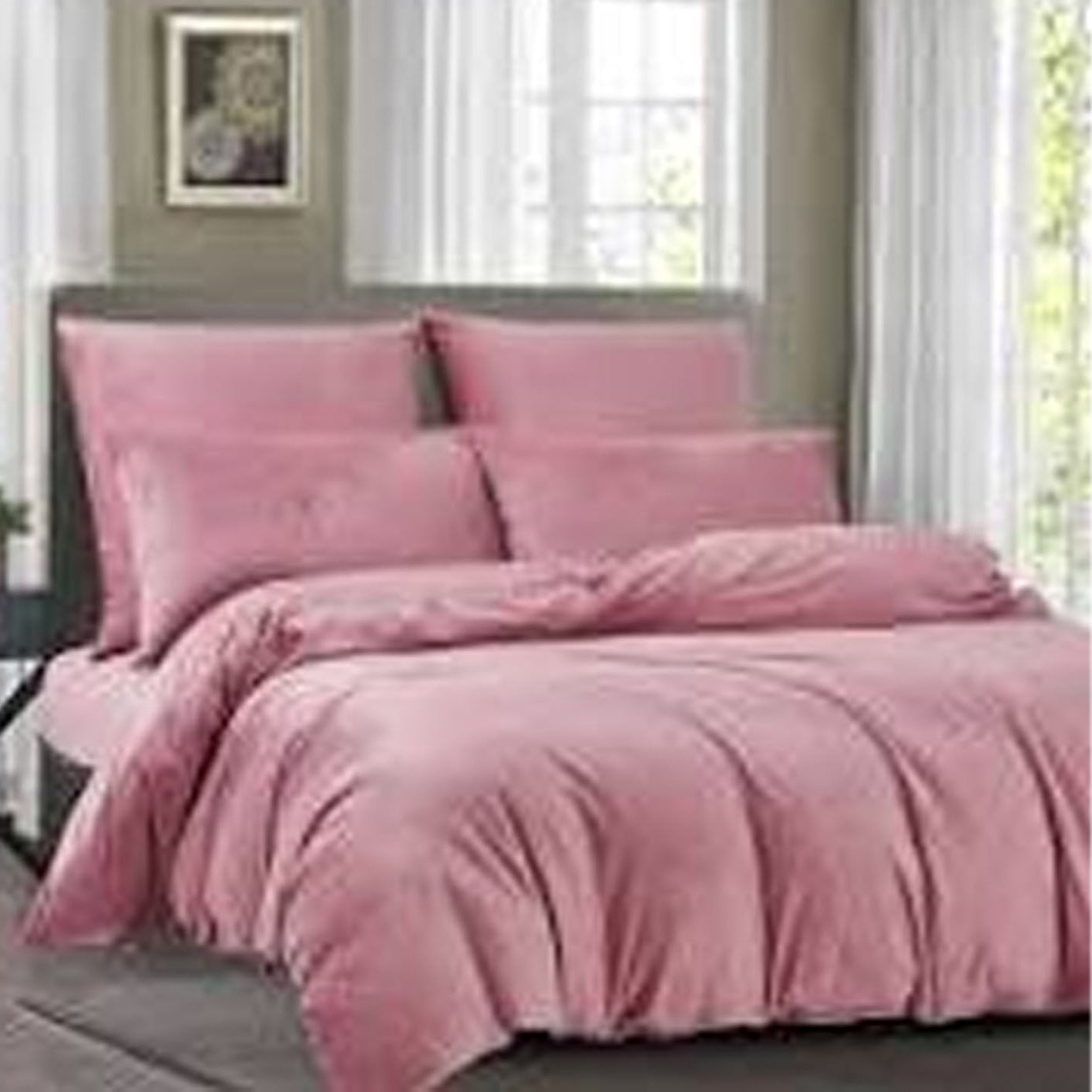 Pink bedding set on a bed in a bedroom with a window in the background