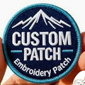 Custom embroidery patch with mountain design held by a hand