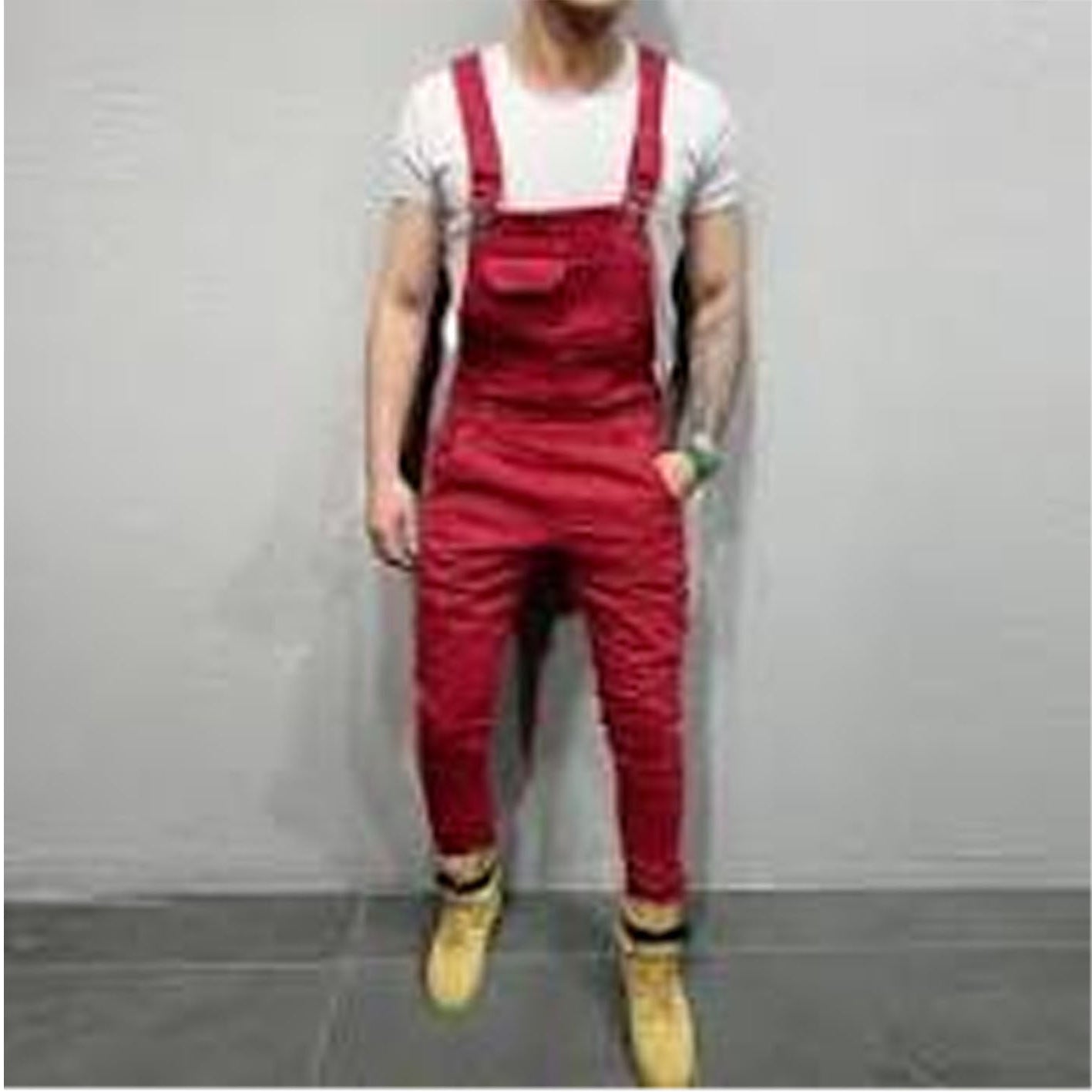 Person wearing red overalls and yellow boots against a gray background