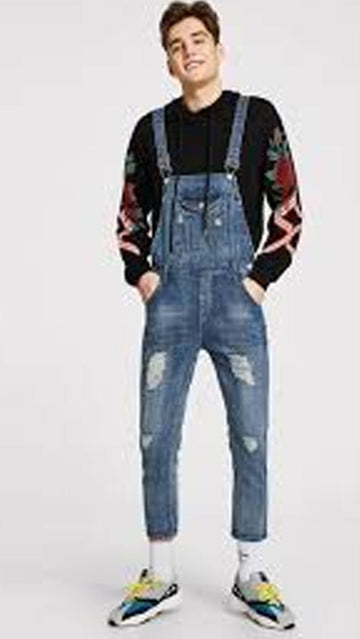 Person wearing blue denim overalls on a white background