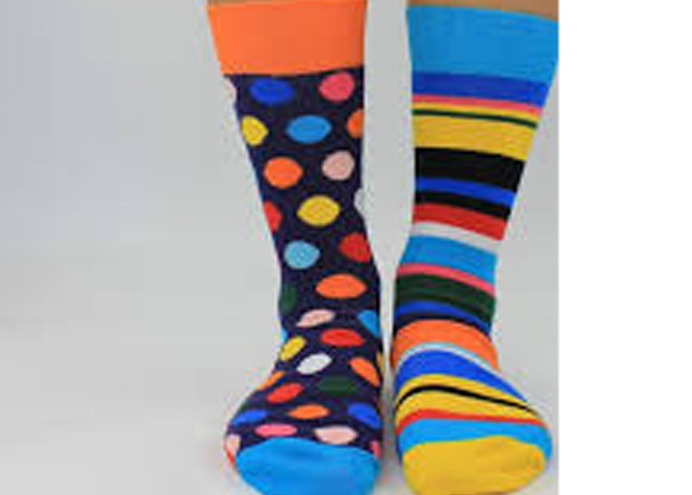 Colorful polka dot and striped socks on a plain background