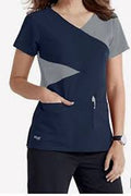 Navy blue scrub top with gray accents worn by a person on a white background