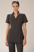 Woman wearing a dark gray professional outfit on a plain background