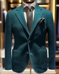 Teal blazer on a mannequin with a blurred indoor background