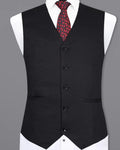 Black vest with a red patterned tie on a gray background