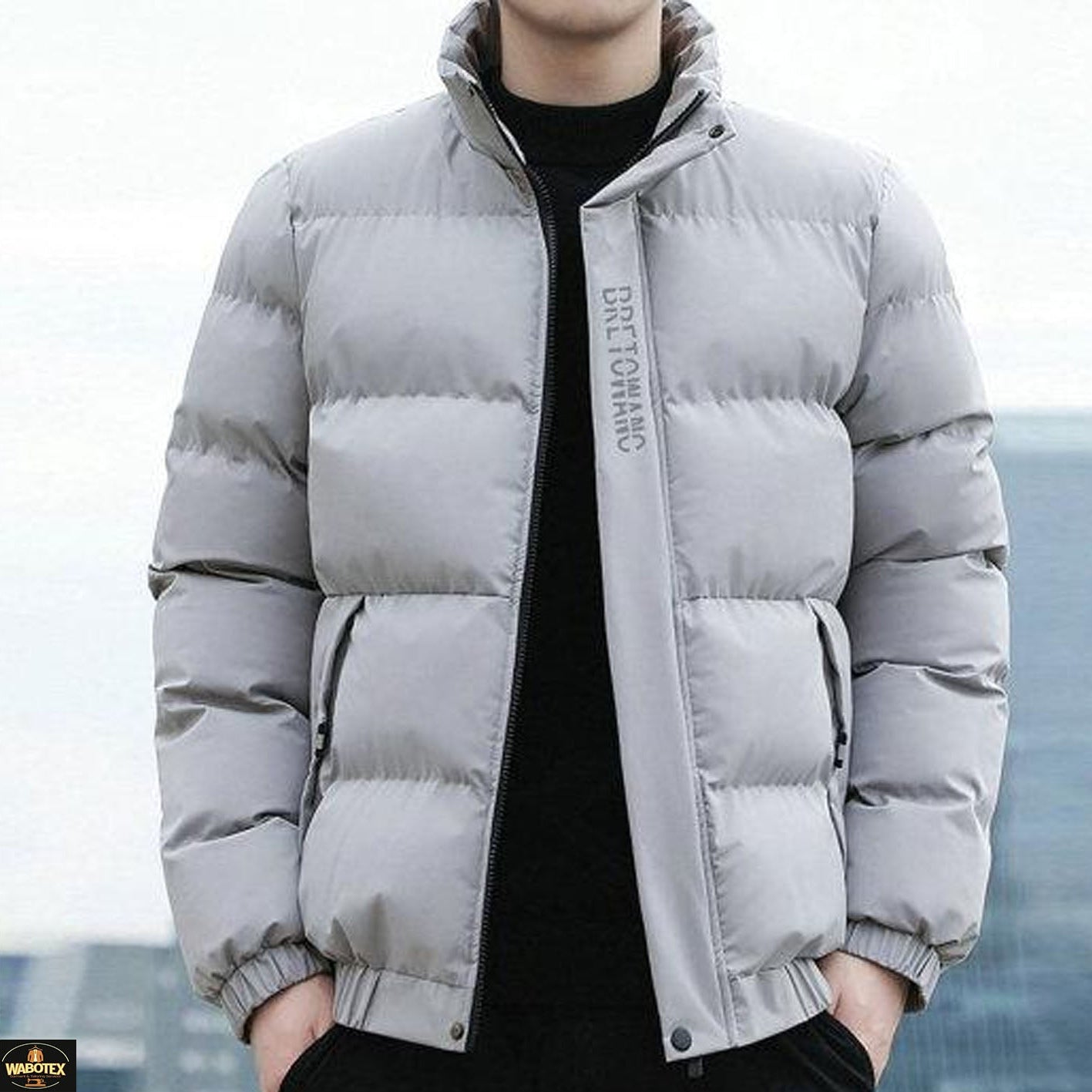 Person wearing a gray puffer jacket with a blurred background
